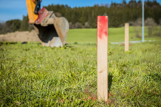 Pfosten und Baggerschaufel auf einer Baustelle